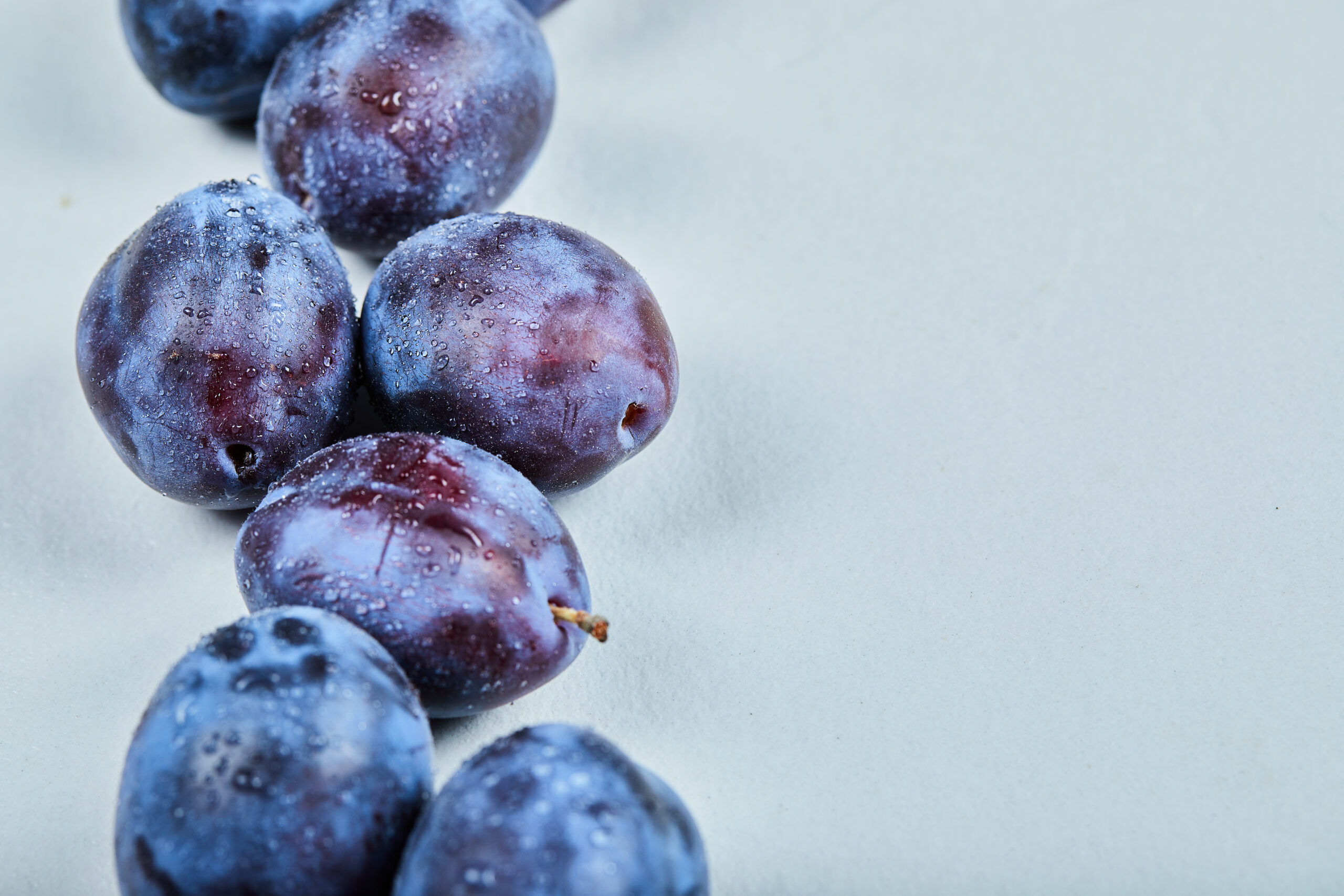 Group of fresh plums on a blue background