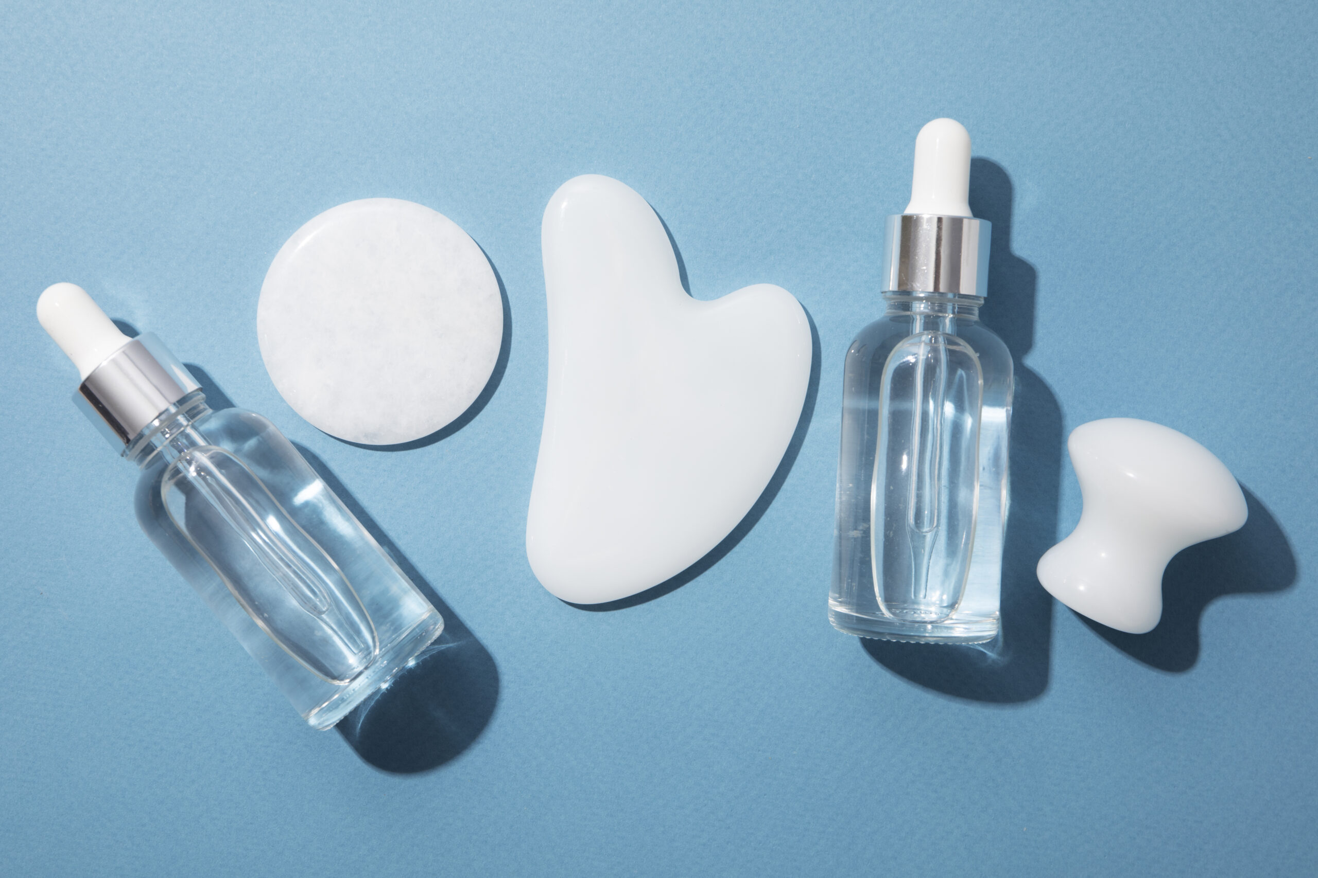 gua-sha-serum-bottles-arrangement-top-view